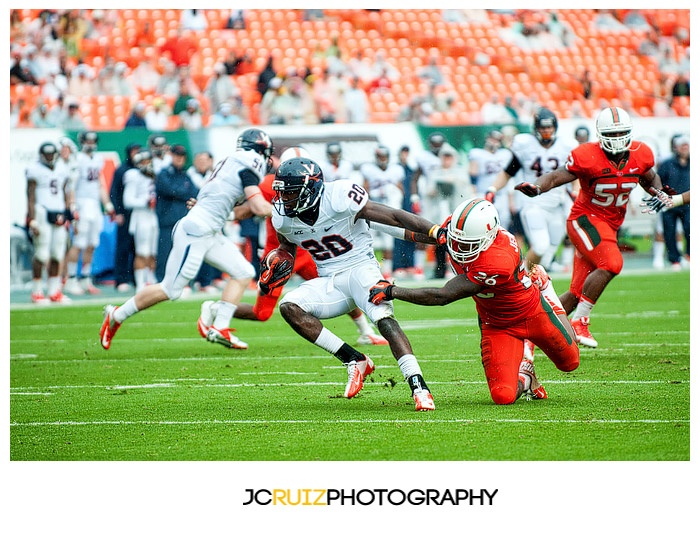 Virginia RB #20, Tim Smith, eludes the tackle of Hurricanes #26, Rayshawn Jenkins