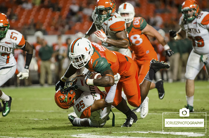 Miami RB Gus Edwards runs over a FAMU defender