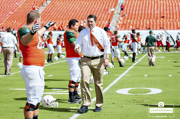 Miami coach Al Golden greets his players at stretching