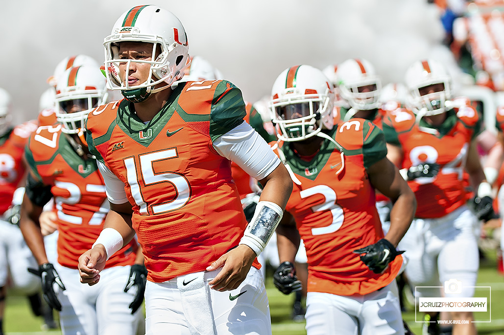 Miami QB Brad Kaaya runs out of the smoke before the game