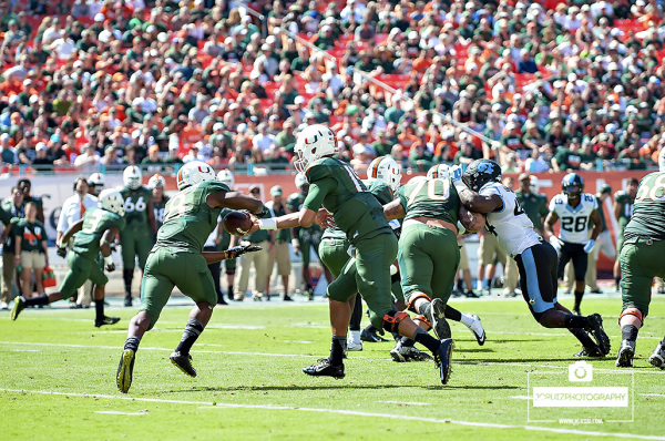 Brad Kaaya hands the ball off to Duke Johnson