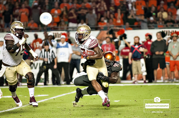Miami Hurricanes DL # 91, Olsen Pierre, attempts to tackle Florida State RB #7, Mario Pender