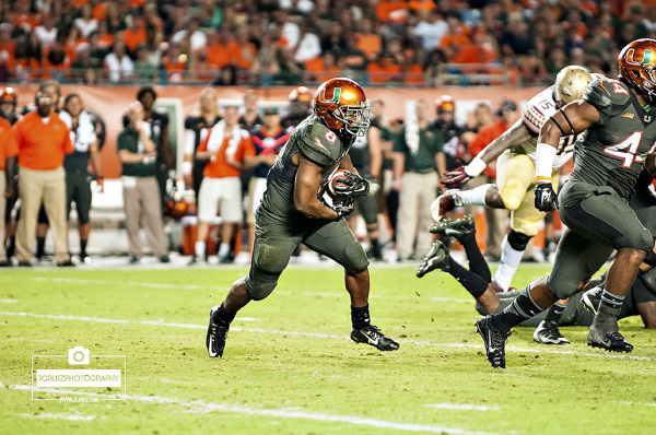 Miami RB #8 Duke Johnson attempts to rush against the Florida State defense