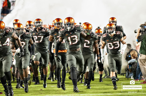 The Miami Hurricanes run through the smoke prior to the game