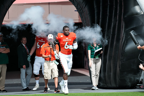 Herb Waters runs through the smoke on Senior Day