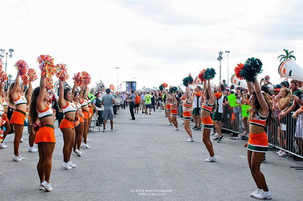 Hurricane cheerleaders and band wait for the team to arrive