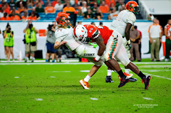 Hurricanes DL, RJ McIntosh, drives FAMU QB, Ryan Stanley, into the ground after a pass attempt