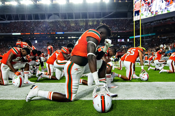 Hurricanes TE, David Njoku, takes a knee in prayer before the game