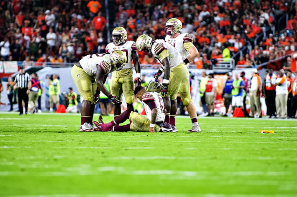 Deondre Francois, Florida State QB, sits on the ground after a hit from the Miami defense