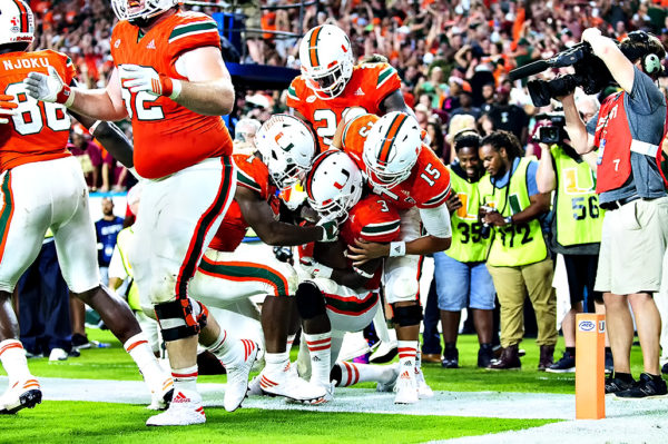 Mark Walton and Brad Kaaya help Stacy Coley celebrate his touchdown