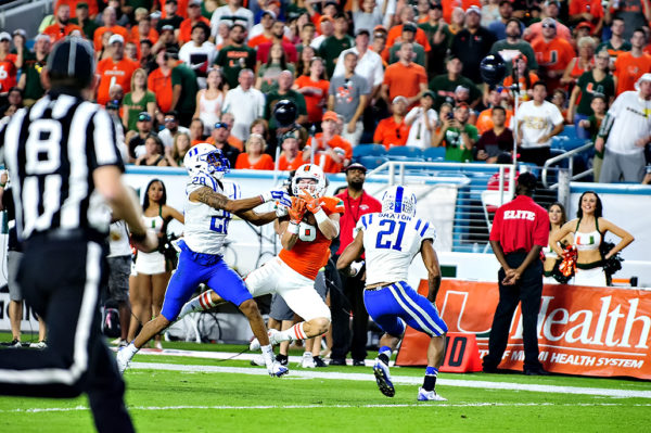 Braxton Berrios makes a catch between two defenders
