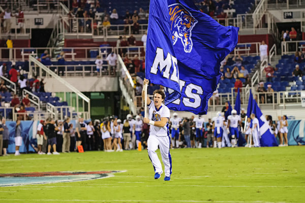 A member of the Memphis cheer squad leads the team onto the field