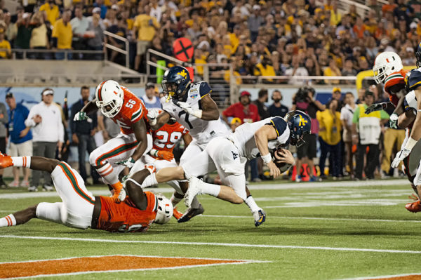 Miami Hurricanes DL, Chad Thomas, wraps up Sklyer Howard from West Virginia