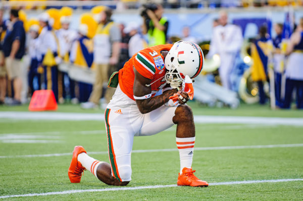 Stacy Coley, Miami Hurricanes WR, take a knee in prayer prior to the conclusion of warmups