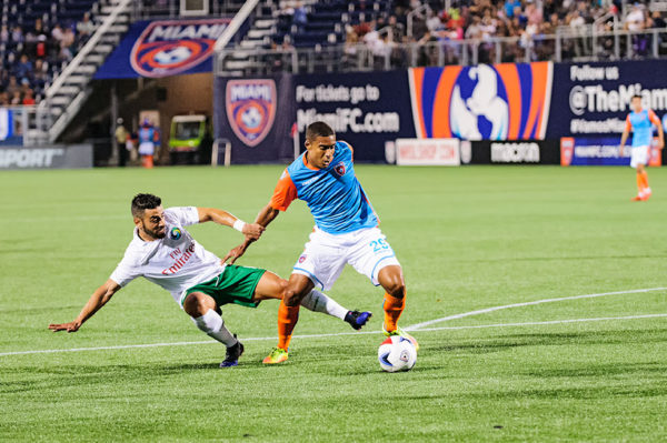 Miami FC forward, Stefano Pinho, tries to keep the ball away from the defender