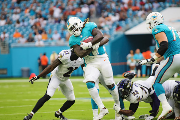 Dolphins RB #23, Jay Ajayi, tries to break tackles