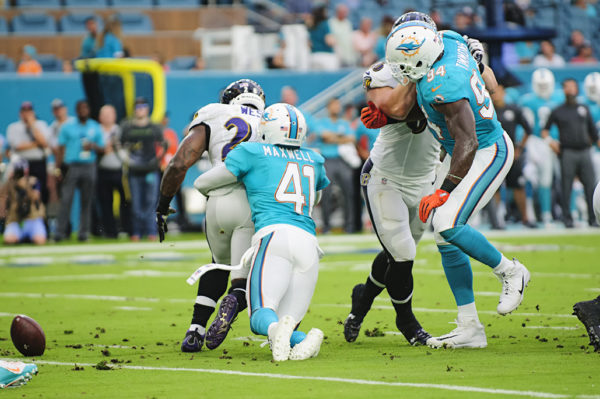 Dolphins CB #41, Byron Maxwell, forces Ravens RB #28, Terrance West, to fumble the ball