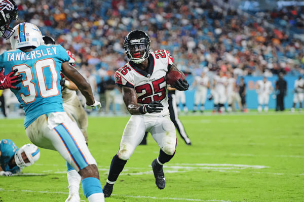 Falcons RB, #25 Brian Hill, looks to run outside to avoid be tackled