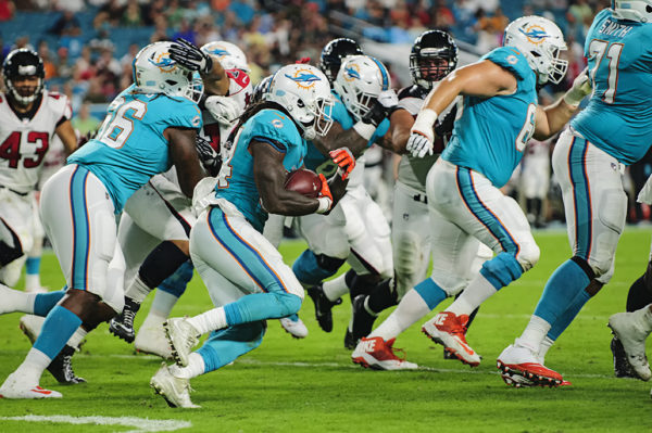 Dolphins RB, #34 Senorise Perry, tries to find a hole to run through