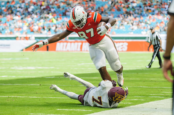 Hurricanes TE, Michael Irvin II tries to leak over a tackle