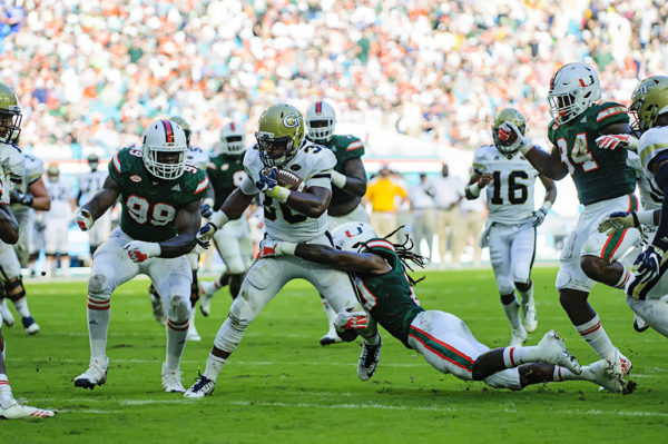 KirVonte Benson (30) tries to avoid the tackle of Robert Knowles (20)