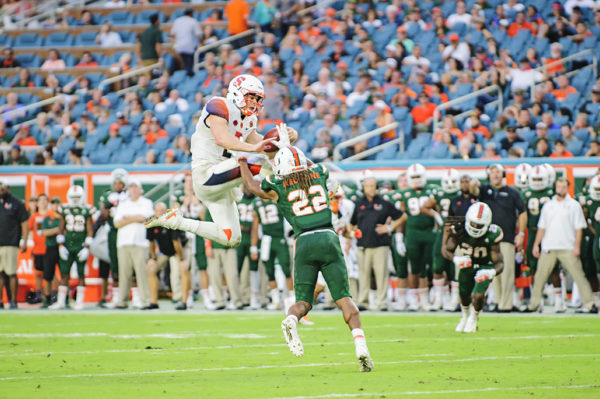 Eric Dungey (2) tries to leap over Sheldrick Redwine (22)