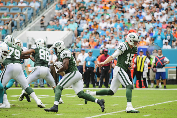 Josj McCown (15) hands off to Bilal Powell (29)