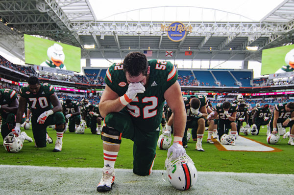 The Hurricane players take a knee prior to the game