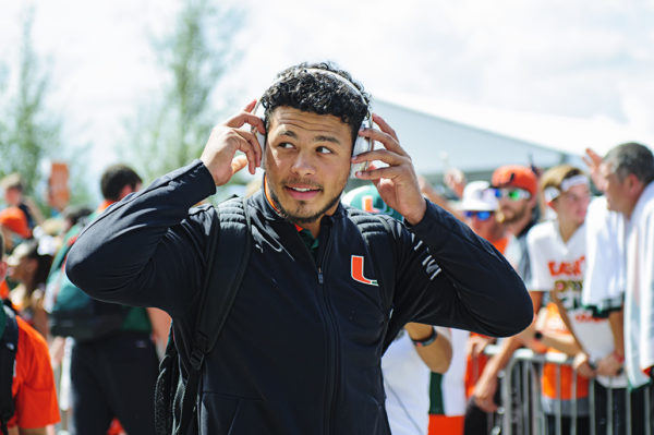 Malik Rosier puts on headphones prior to entering the stadium from Canes Walk