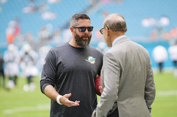 Defensive Coordinator, Matt Burke, speaks with owner Stephen Ross