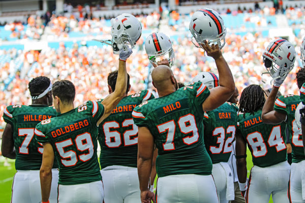 Players raise their helmet prior to kick-off