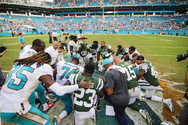 Players say a prayer at the 50 yard line