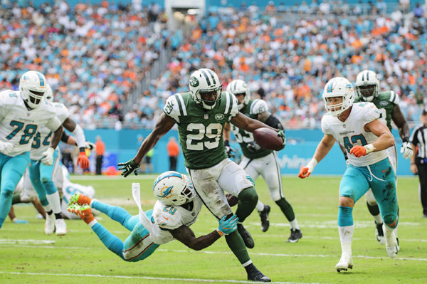 Reshad Jones (20) flies in to tackle Bilal Powell (29)