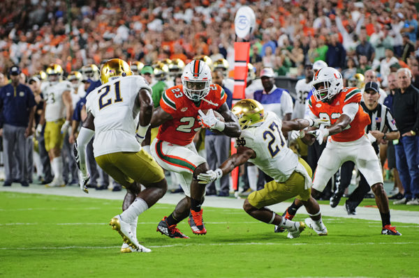 Hurricanes TE Chris Herndon (23) tries to run between two would be tacklers