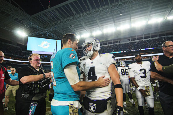 Jay Cutler (6) and Derek Carr (4) talk to one another after the game