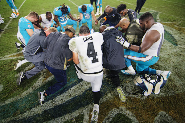 Players gather at the 50 yard line for a prayer