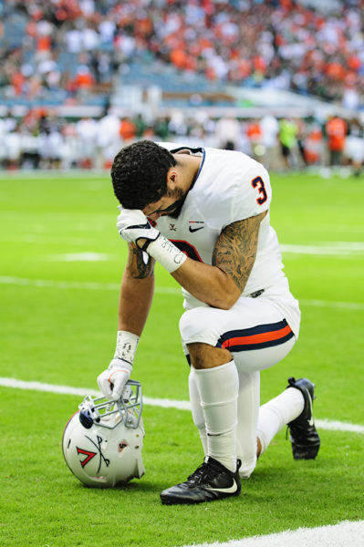 Quin Blanding (3) takes a knee prior to the game