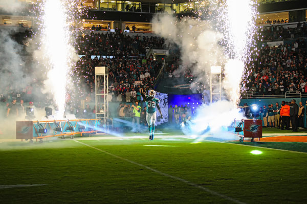 Kenyan Drake points to the sky as fireworks go off behind him