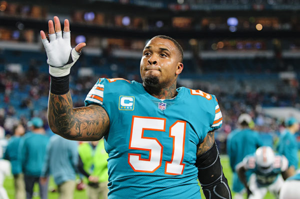 Dolphins center Mike Pouncey waves to fans during warmups