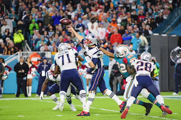 Tom Brady throws with pressure around him