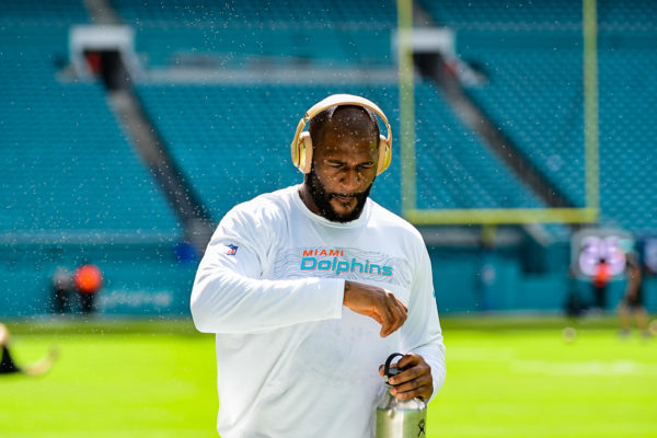 Miami Dolphins defensive end Andre Branch (50) walks through a wall of gnats during warmups