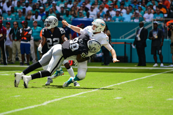 Oakland Raiders defensive end Arden Key (99) hits Miami Dolphins quarterback Ryan Tannehill (17) as he throws