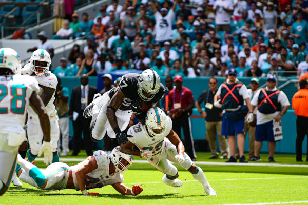 Oakland Raiders tight end Jared Cook (87) tries to leap over Miami Dolphins defensive back Minkah Fitzpatrick (29) and Miami Dolphins linebacker Kiko Alonso (47)