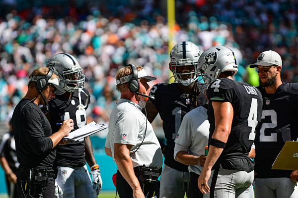 Coach Jon Gruden talks to Oakland Raiders quarterback Derek Carr (4) during a timeout