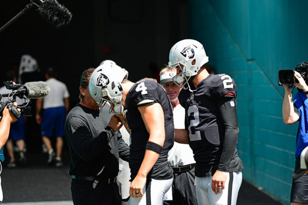 Oakland QBs have a quick little huddle before running onto the field