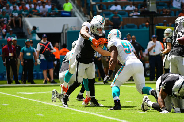 Miami Dolphins defensive end Robert Quinn (94) hits Oakland Raiders quarterback Derek Carr (4) as he throws