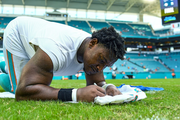 Miami Dolphins defensive tackle Akeem Spence (93) signs his jersey