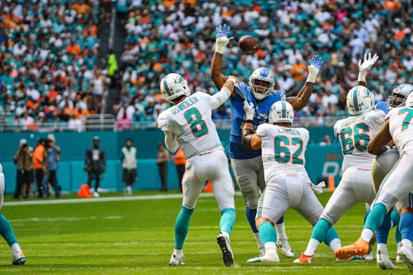 Miami Dolphins quarterback Brock Osweiler (8) throws a pass between the hands of Detroit Lions defensive end Da'Shawn Hand (93)