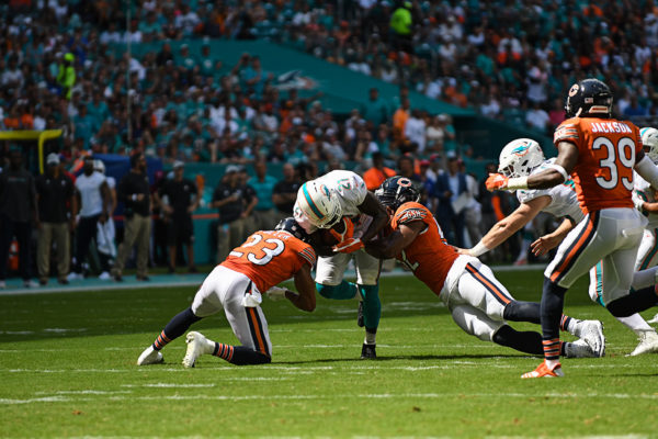 Miami Dolphins running back Frank Gore (21) gets tackled by Chicago Bears outside linebacker Khalil Mack (52) and Chicago Bears cornerback Kyle Fuller (23)