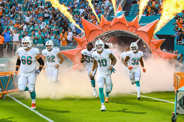 Miami Dolphins run through the smoke and fire
